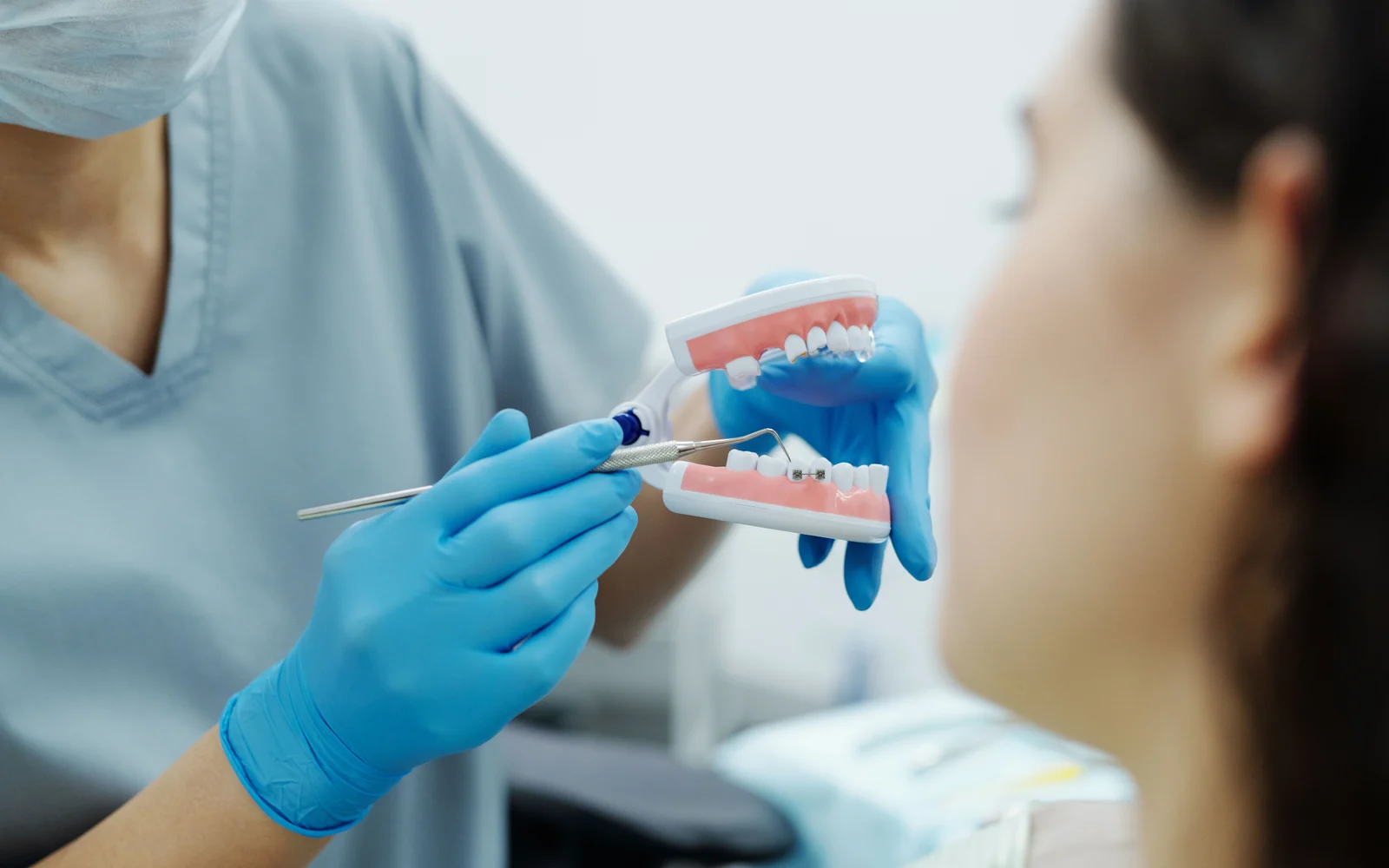 Dentist demonstrating tooth concerns with a dental model during endodontic treatment planning.