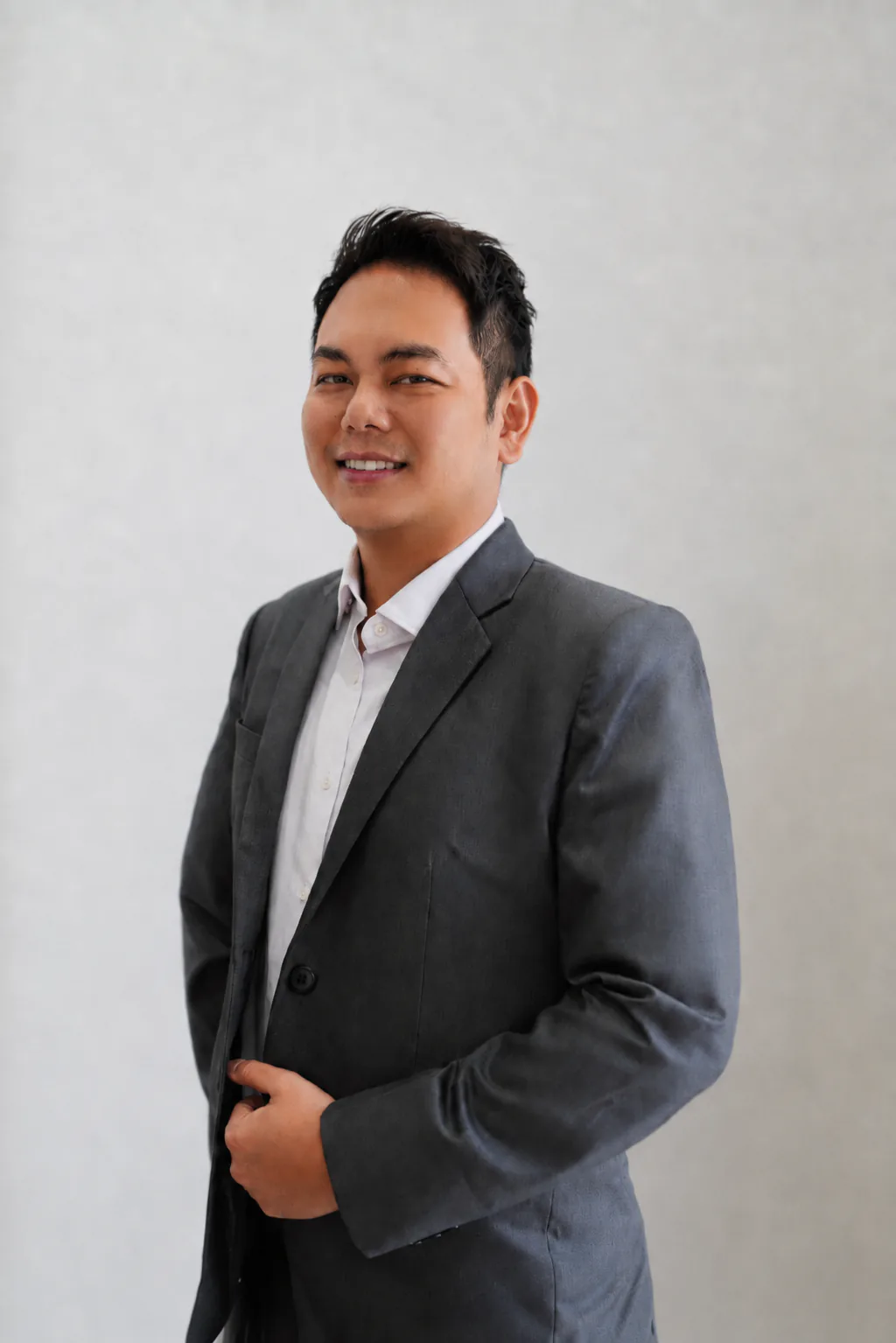 Portrait of Dr Jason Loo in a dark blue suit and shirt.