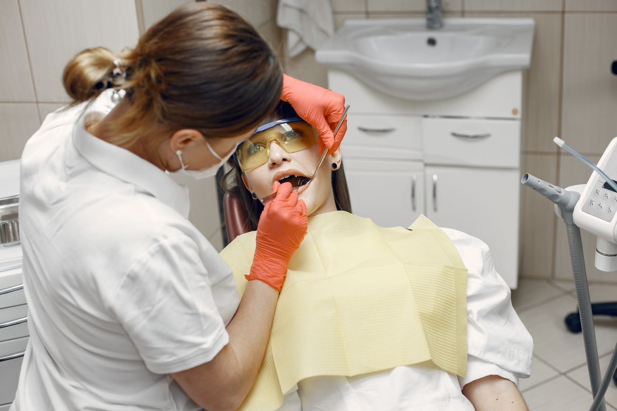 Dentist examining a patient in a dental chair before treatment planning.