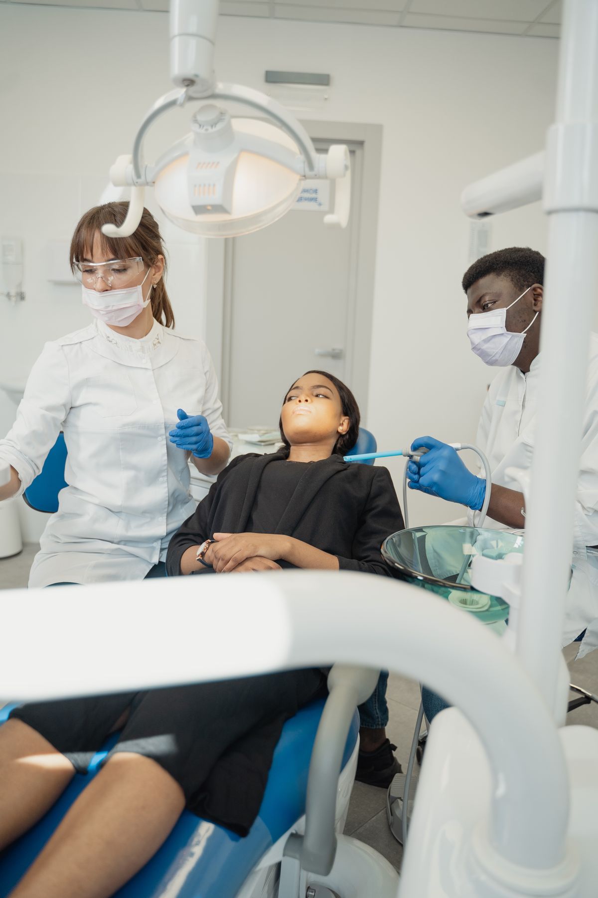 Dentist and assistant examining a patient in a dental clinic.